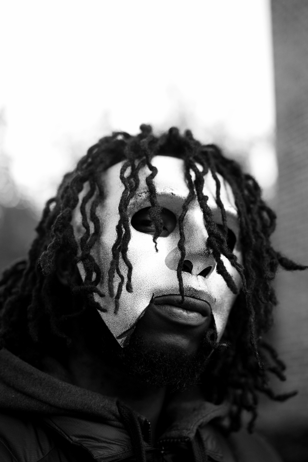 Black and white portrait with locs falling over the face, for i-D