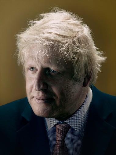 A portrait of Boris Johnson against an ochre ground, half his face falling into shadow — photograph by Nadav Kander